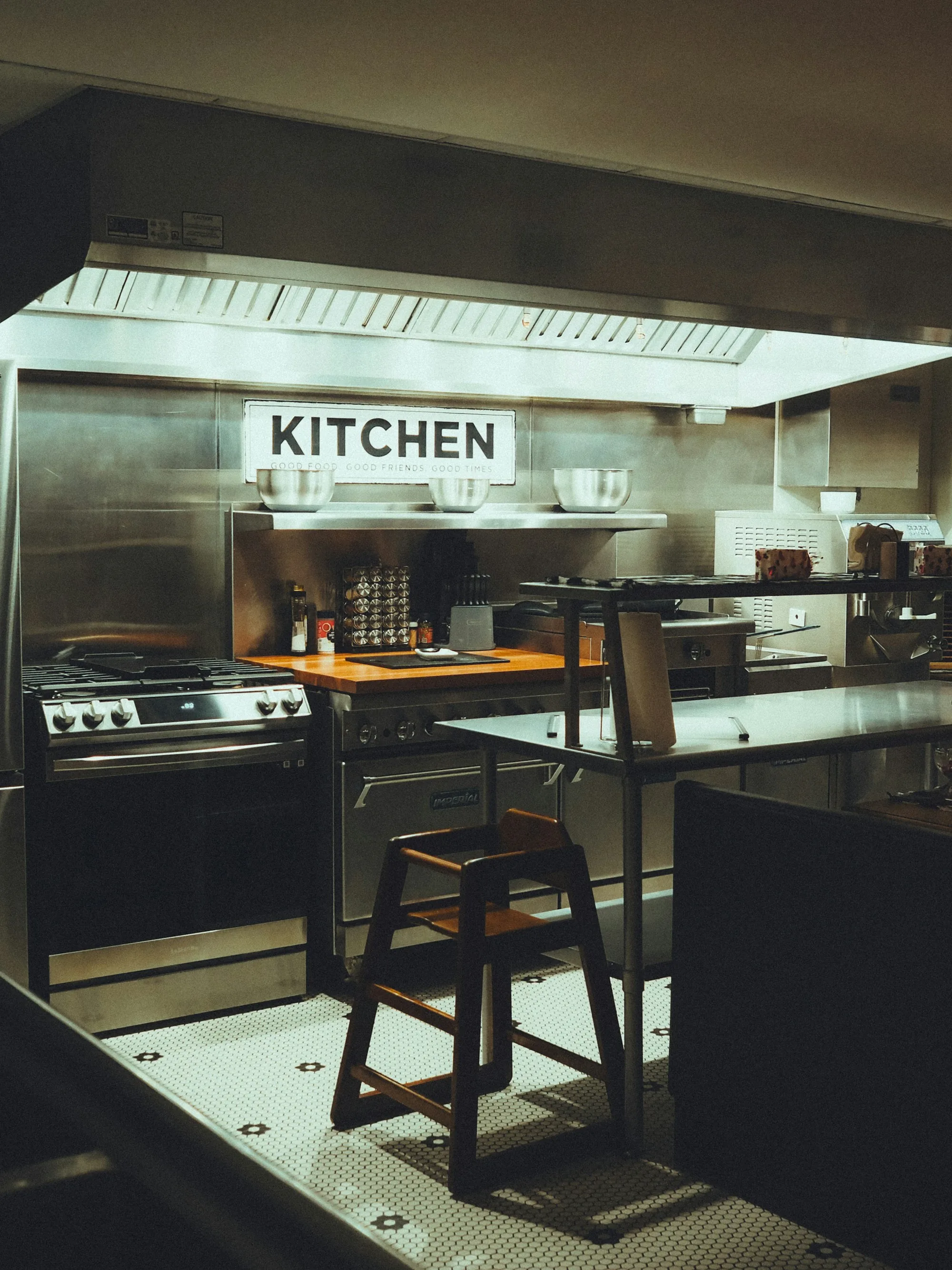 Empty wooden stool in a darkened restaurant kitchen — the visual metaphor for what is left behind when a key employee leaves